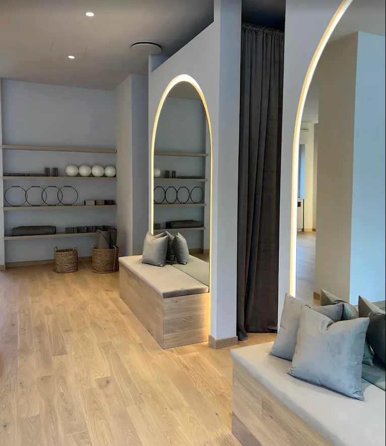 Zona accoglienza Aelisa con sedute, specchi ad arco e accessori Pilates
